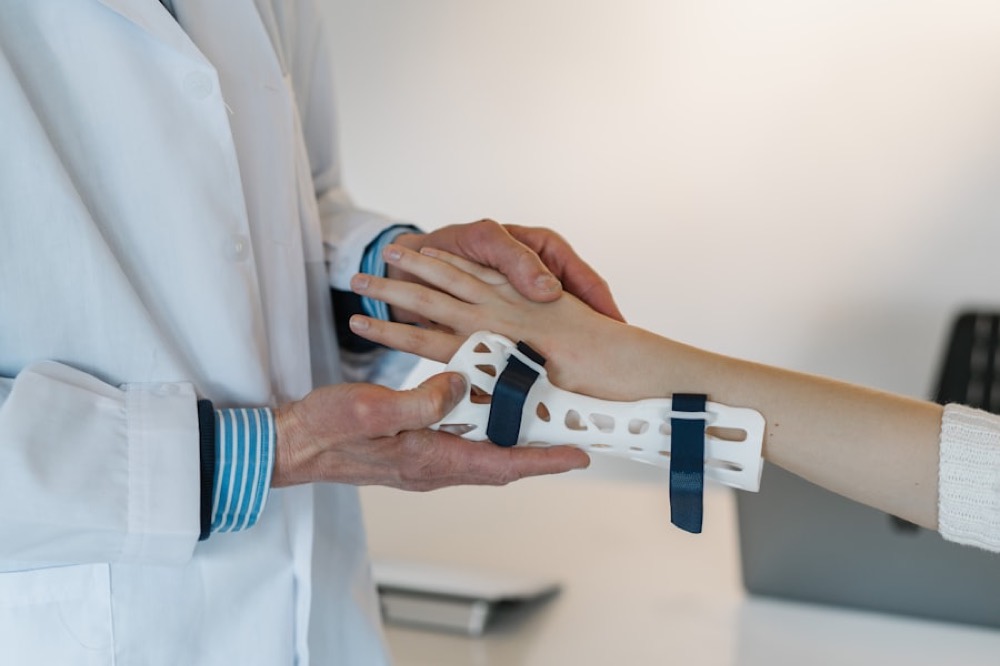 Clinician fitting a supportive wrist splint on a patient at the Astoria clinic